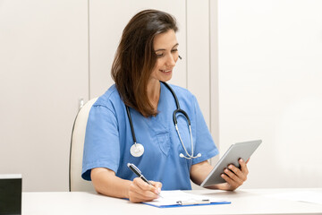 Doctor explaining with patient via tablet computer, mobile health application.