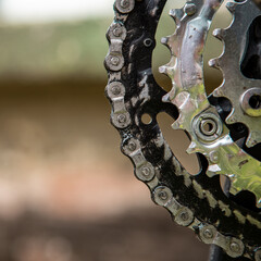 Close-up of gears and a chain to drive a bicycle. The chain is dirty and greasy. Copy space