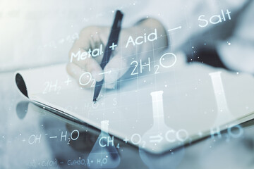 Double exposure of creative chemistry concept with man hand writing in notebook on background, research and development concept