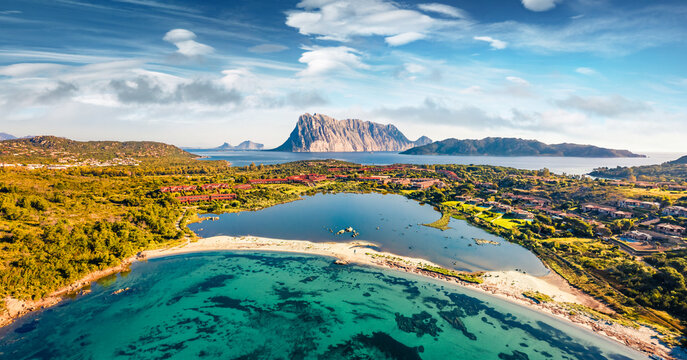 Panoramic spring view from flying drone of Salina Bamba beach with Tavolara mountain on background. Wonderful morning scene of Sardinia island, Italy, Europe.
