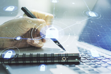 Double exposure of creative lock hologram with chip and hand writing in notebook on background with...