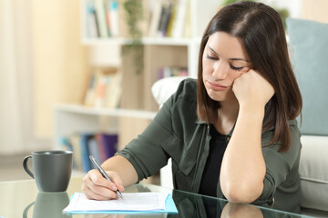 Frustrated woman filling form at home