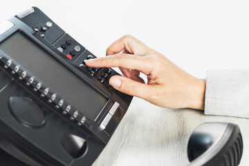 business and communications. Using voip phone in the office, close up of hand with receiver. Conference call, contact us or hotline. IP telephony, Telemarketing. Help desk or call center