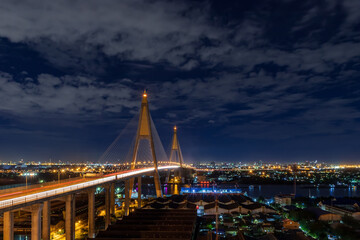 Large suspension bridge over Chao Phraya river with traffic at night