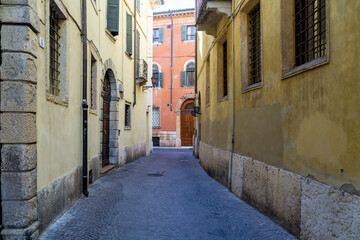 Fototapeta na wymiar Narrow empty street in the old medieval town of Verone in the Veneto Region, Italy. 