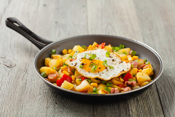 Traditional American hash with fried eggs. Front view.