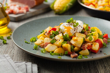 Traditional American hash with fried eggs. Front view.