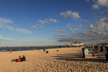 Obraz premium Herbstliche Abendsonne am Ostseestrand; Strandleben an der Seebrücke in Ahlbeck