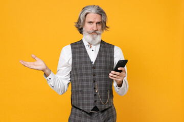 Puzzled elderly gray-haired business man in suit waistcoat shirt using mobile cell phone typing sms...