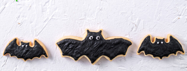 Top view of Halloween festive decorated icing sugar cookies on white background.