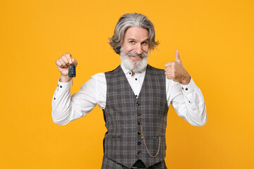 Smiling funny elderly gray-haired business man in checkered waistcoat suit white shirt hold car keys showing thumb up isolated on yellow background studio portrait. Achievement career wealth concept.