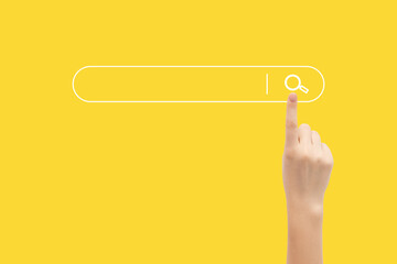 Finger presses the search button in the search bar on a yellow background.