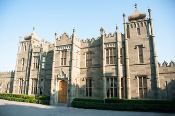 Fototapeta premium The castle in the neo-moorish style with battlements and towers surrounded by the lush garden. Decorative elements of the Vorontsov Palace. Gray basalt walls.