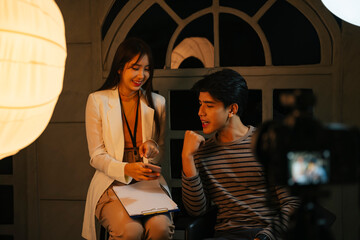 Influencer and MC doing interview for TV show at studio indoors.