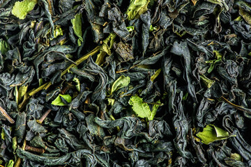 Black large-leaf tea as a background. Texture of dry black tea leaves.