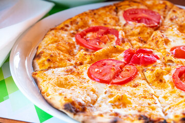 Classic pizza with tomatoes on a plate.