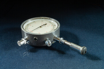 Mechanical tachometer with arrow on black background