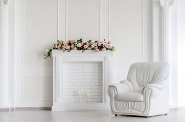 White empty room interior with armchair and fireplace decorated with roses - hotel living room interior