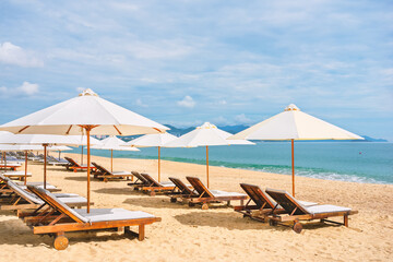 Empty sea beach with sun lounge and umbrella