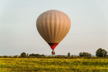 Naklejka premium Hot air balloon in the sky low above the ground