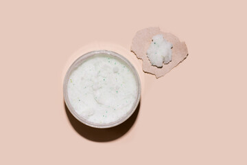 Body and face scrub on a beige background. View from above.