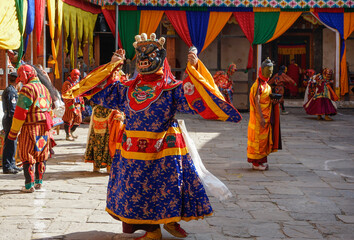 Naklejka premium Bhutan, in the village of Bumthang, a monk mask dancer in his colourful costume dances at the festival of Jakar.