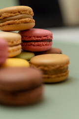 Colored tasty macaroons over a green background.