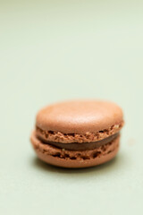 Colored tasty macaroons over a green background.