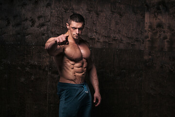 Sporty and healthy muscular man on dark grunge background - 386396707