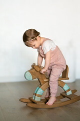 child playing with a wooden toy horse at home