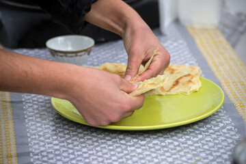Closeup of hands of algerian woman making msemens at the market
