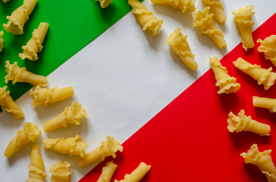 Dry gigli pasta on green-white-red background.