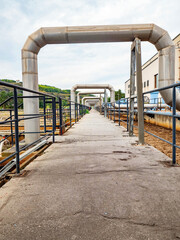 Industrial pipelines in loop on pipe bridge. Tanks field in wastewater treatment plant