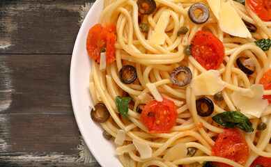Spaghetti pasta with olives and tomatoes and empty space for text