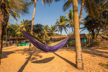 Obraz na płótnie Canvas Amazing day view on the beach of Gokarna : hammock and small cafe at distance