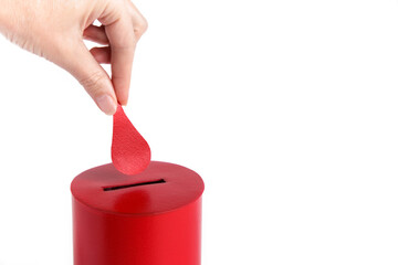 Blood donor. Hand puts drop of blood in the Box as donation on white background. Concept donate...