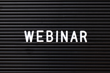 Black color felt letter board with white alphabet in word webinar background