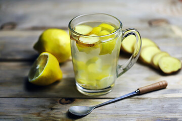 Ginger lemon drink in a glass mug. A healthy hot drink for colds and viruses. Home remedies for colds