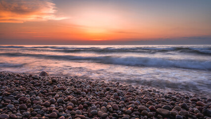 Colorful sunset over the sea and rocky shore