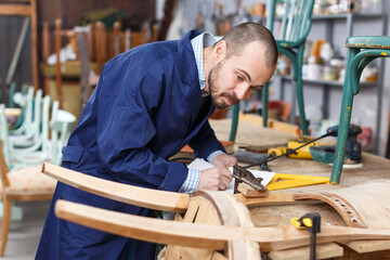 Craftsman engaged in retro chair repair in modern workshop