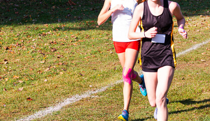 Two female runners battling each other during a cross country race