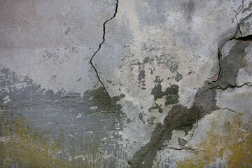 Huge cracks in a grey concrete wall of the house. Close up. The destruction of buildings,...