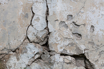 Huge crack of a concrete wall. Fragment of old castle wall, for background or texture. The destruction of buildings, violations of the construction.
