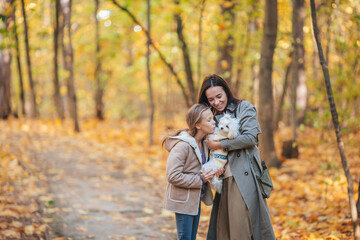 Fototapeta premium Little girl with mom outdoors in park at autumn day