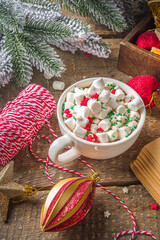 Hot chocolate with marshmallows, warm chocolate drink for Christmas morning breakfast, on wooden background with Christmas decorations, cozy winter pic copy space