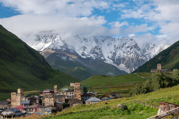 Fototapeta na wymiar Ancient authentic village Ushguli, the Svaneti UNESCO World Heritage Site and one of the highest settlements in Europe. Bezengi wall and mount Shkhara, the highest mount in Georgia, on the background.