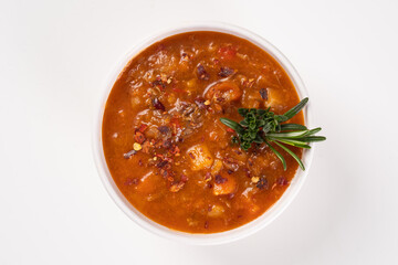 Borscht soup in a white bowl on white background. Top view. Famous traditional Ukrainian and Russian soup with beetroot and cabbage.
