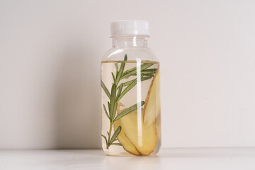 Detox Infused Water with Ginger and Rosemary in Bottle on a White Background. Healthy Beverage. Food diet concept. Vegetarian.