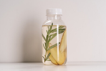 Detox Infused Water with Ginger and Rosemary in Bottle on a White Background. Healthy Beverage. Food diet concept. Vegetarian.