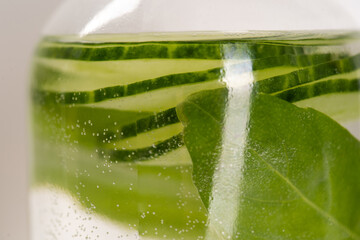 Detox Infused Water with Cucumber and Herbs in Bottle on a White Background. Healthy Beverage. Food diet concept. Vegetarian.